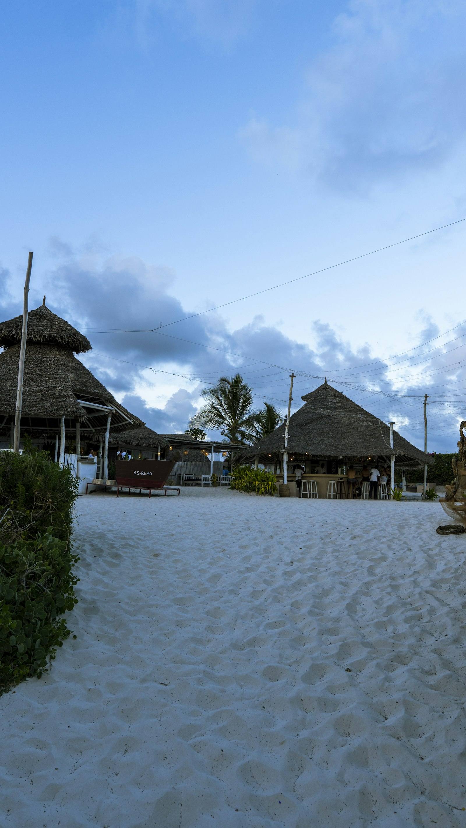 Evening on a Watamu beach, makuti roofs and white sand. Photograph by Isaac Mugwe.